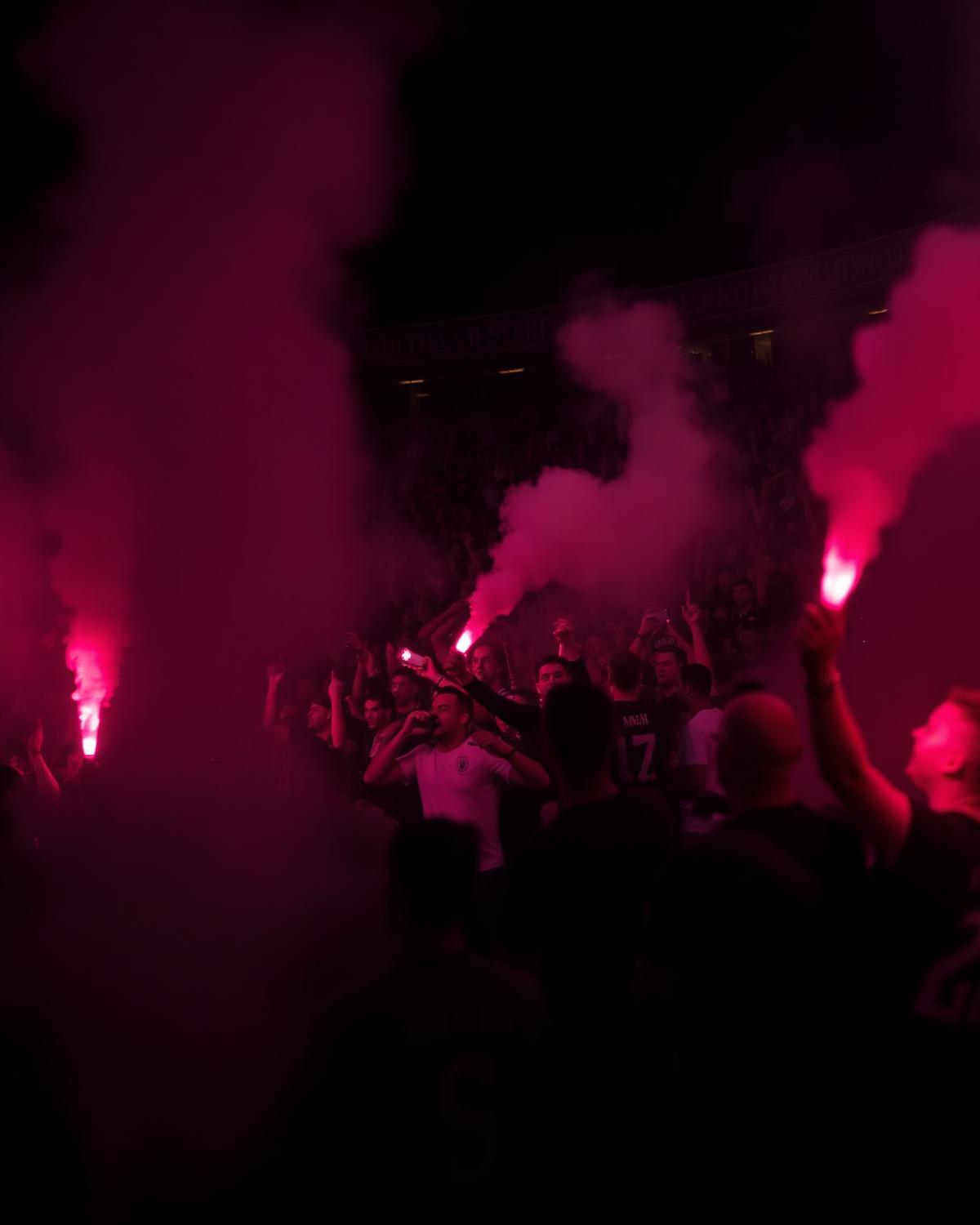 Fans celebrating with flares in a stadium